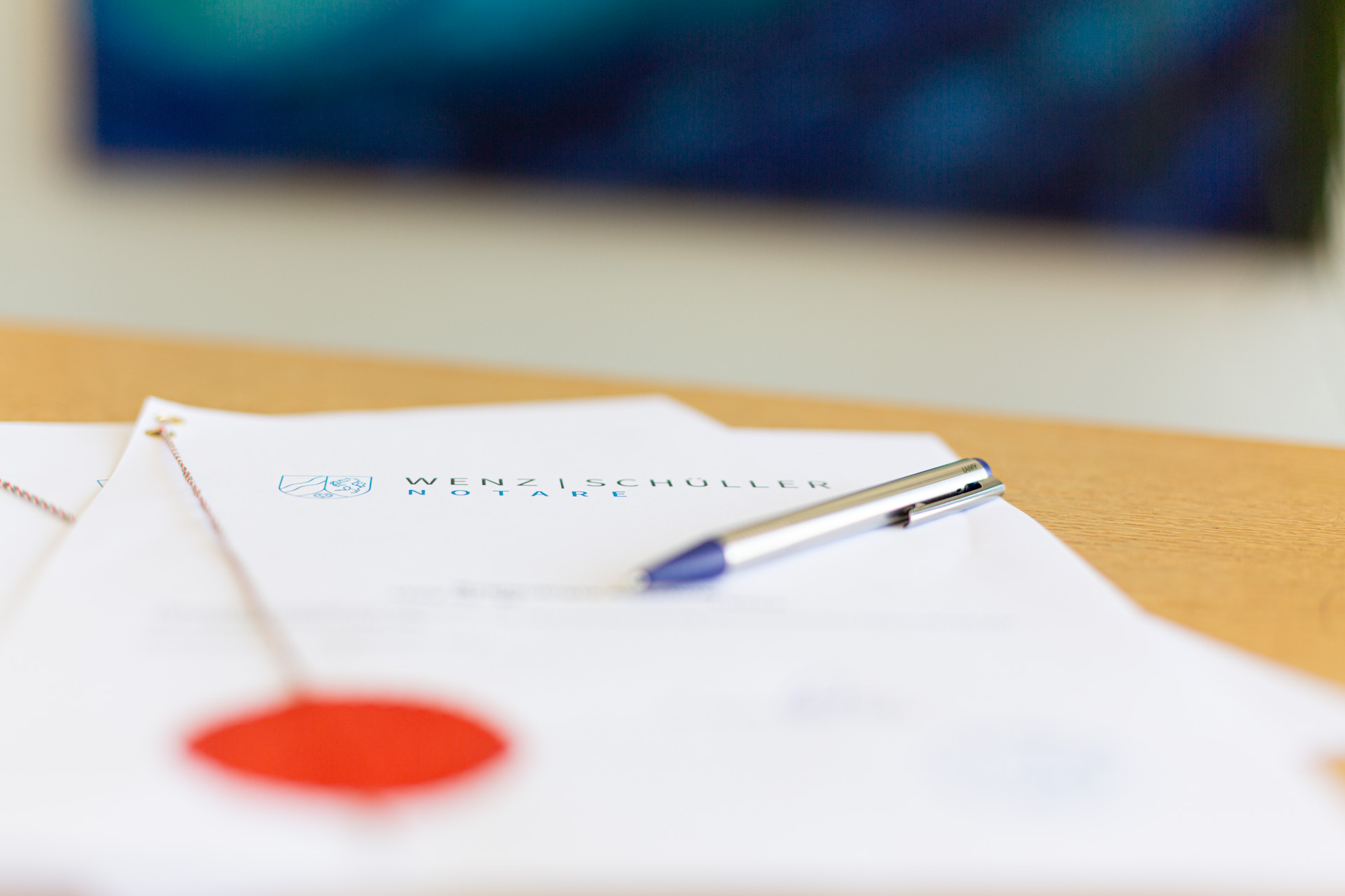 Notare-Wenz-Schueller-Office_20230810_MG_8329 Eine Urkunde des Notariats, auf der ein Stift liegt